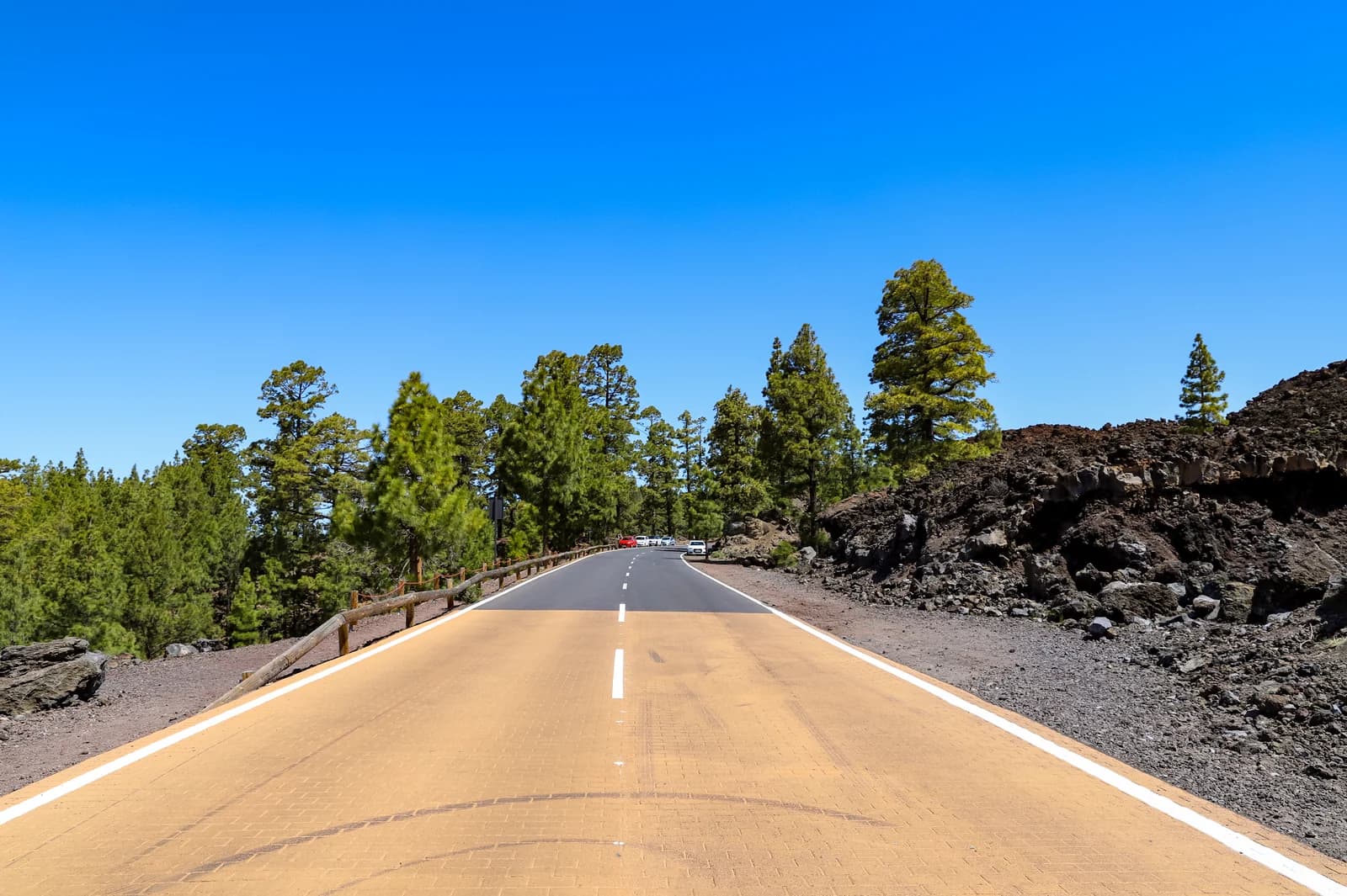 The TF-38 road running straight across dark lava fields toward Mount Teide in Teide National Park, Tenerife