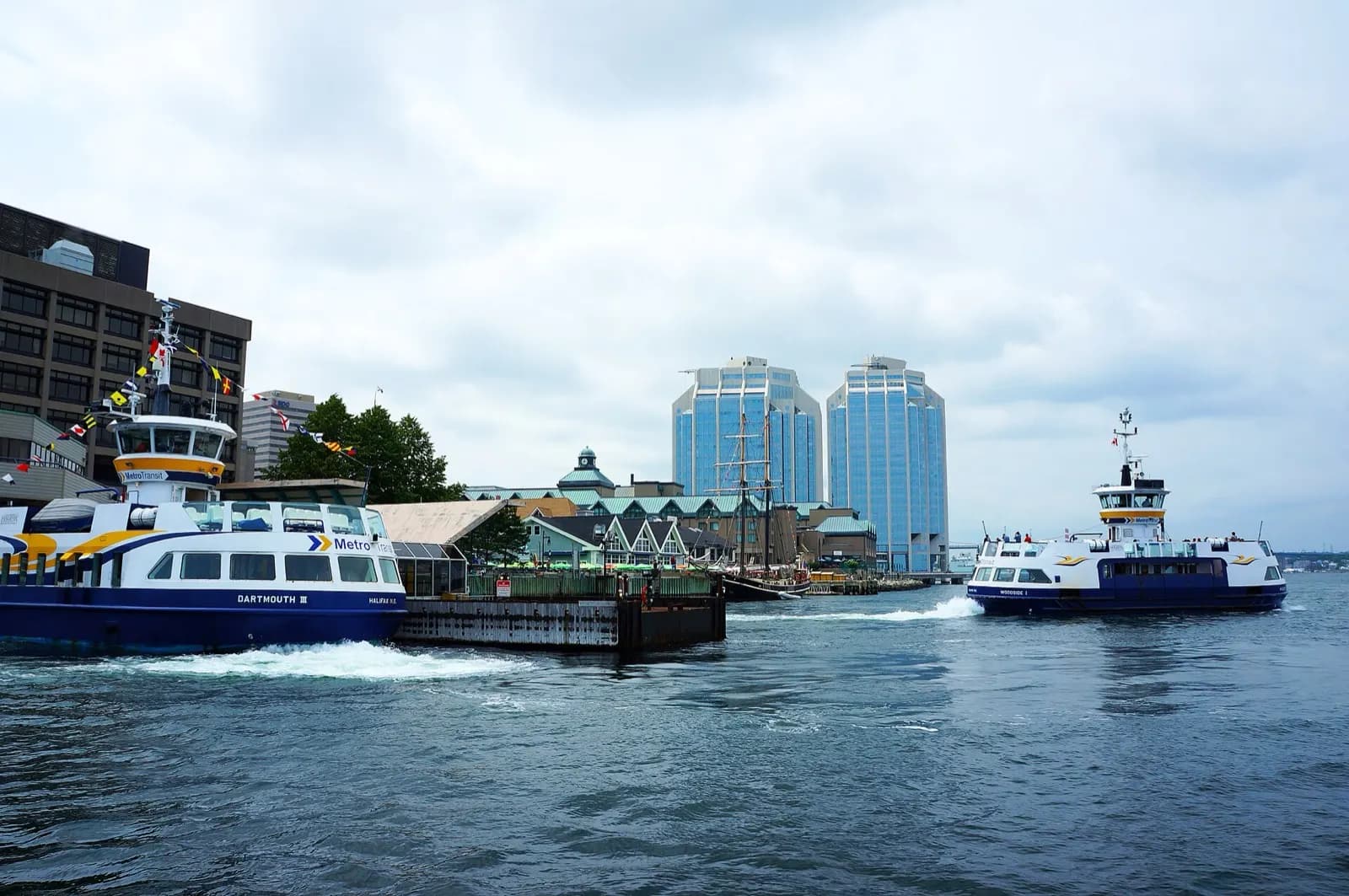Ferries crossing Halifax harbour in Nova Scotia with the waterfront behind