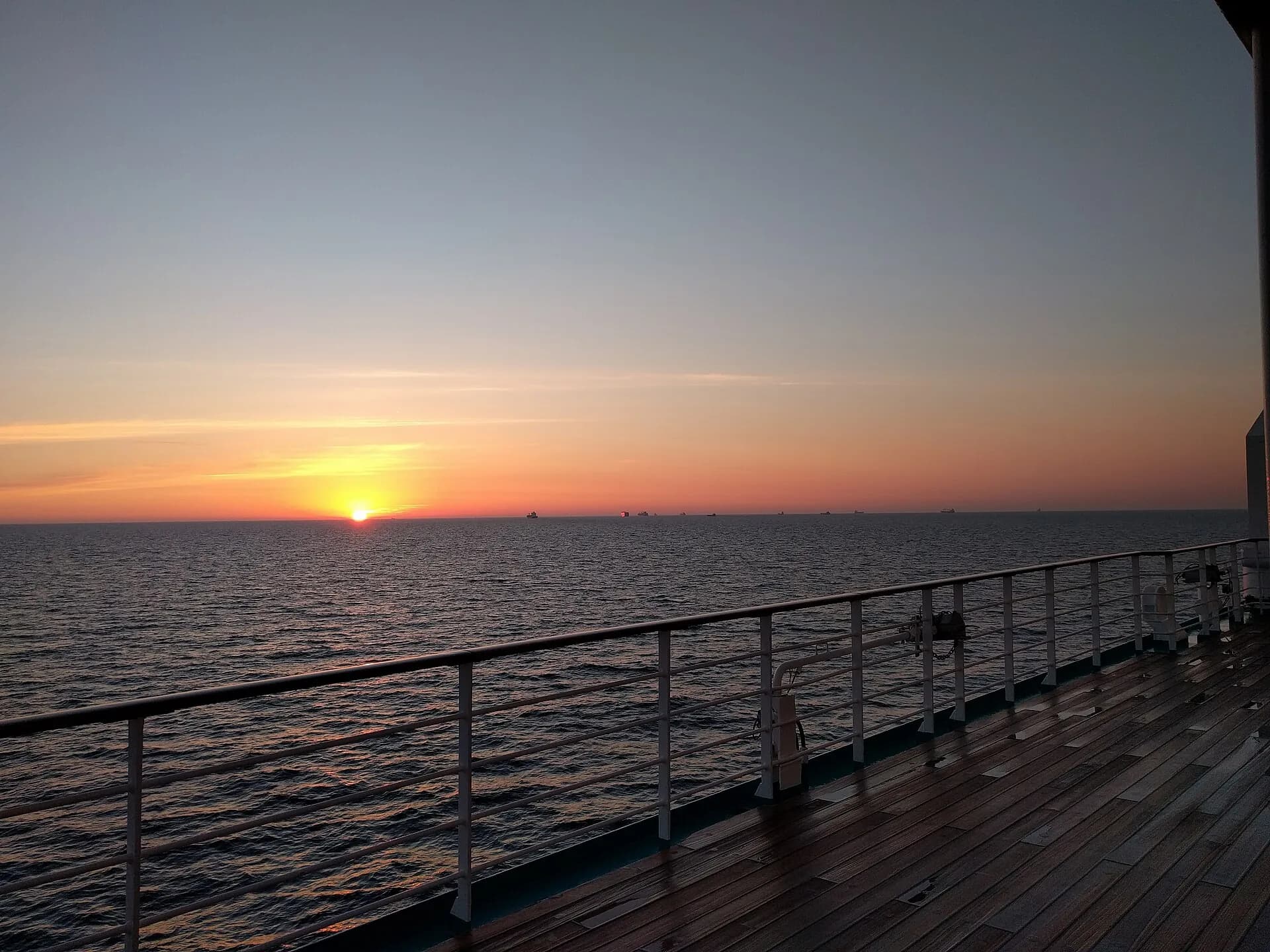 Sunset over the open sea seen from the deck of a cruise ship
