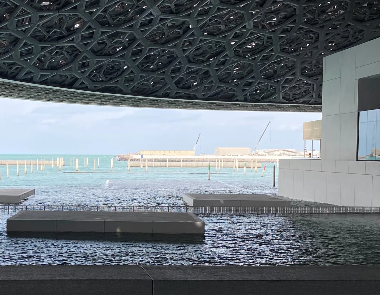 The perforated dome of Louvre Abu Dhabi over the water, ninety minutes from Dubai