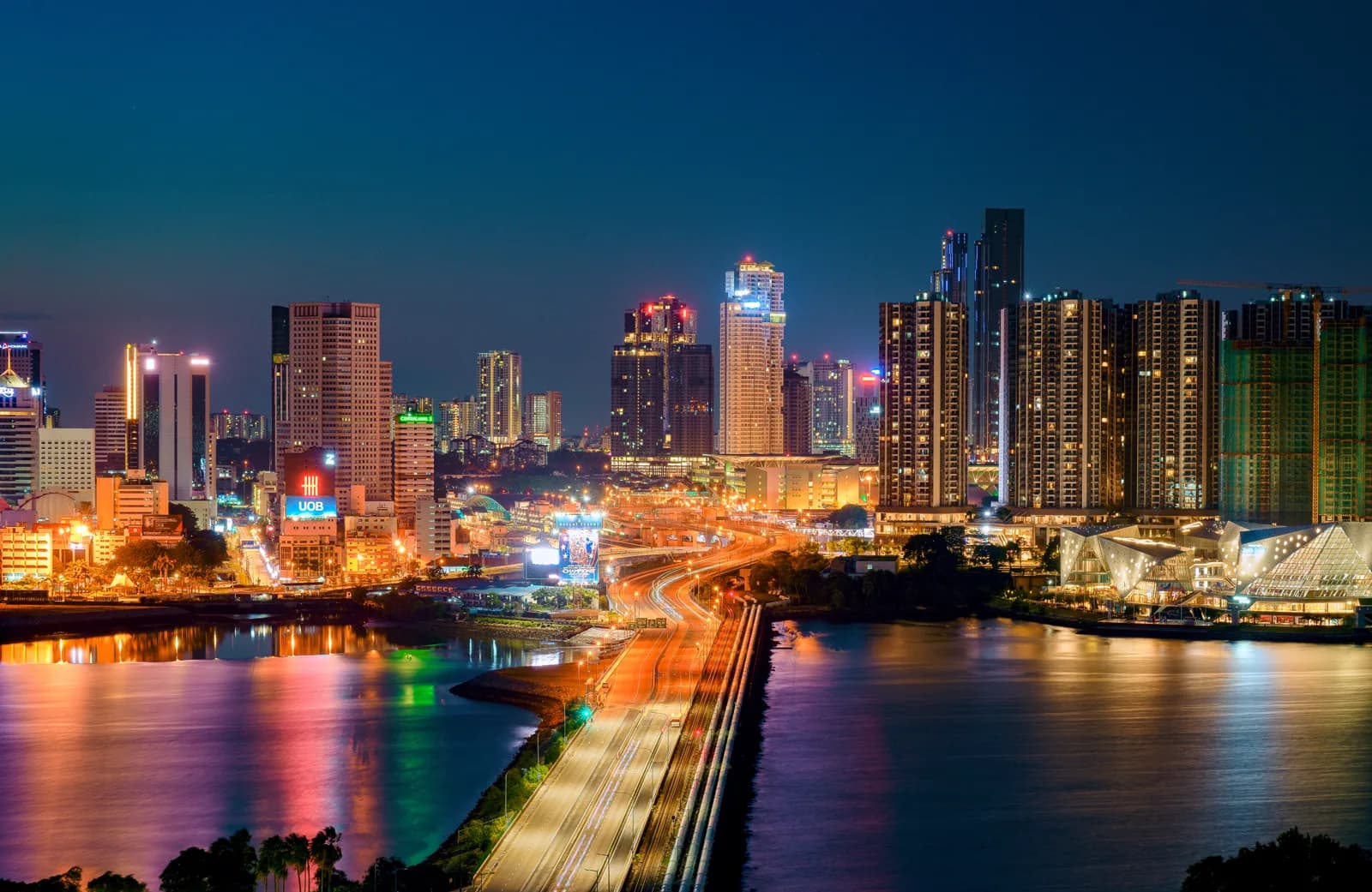 The Johor Bahru skyline lit at night across the causeway from Singapore