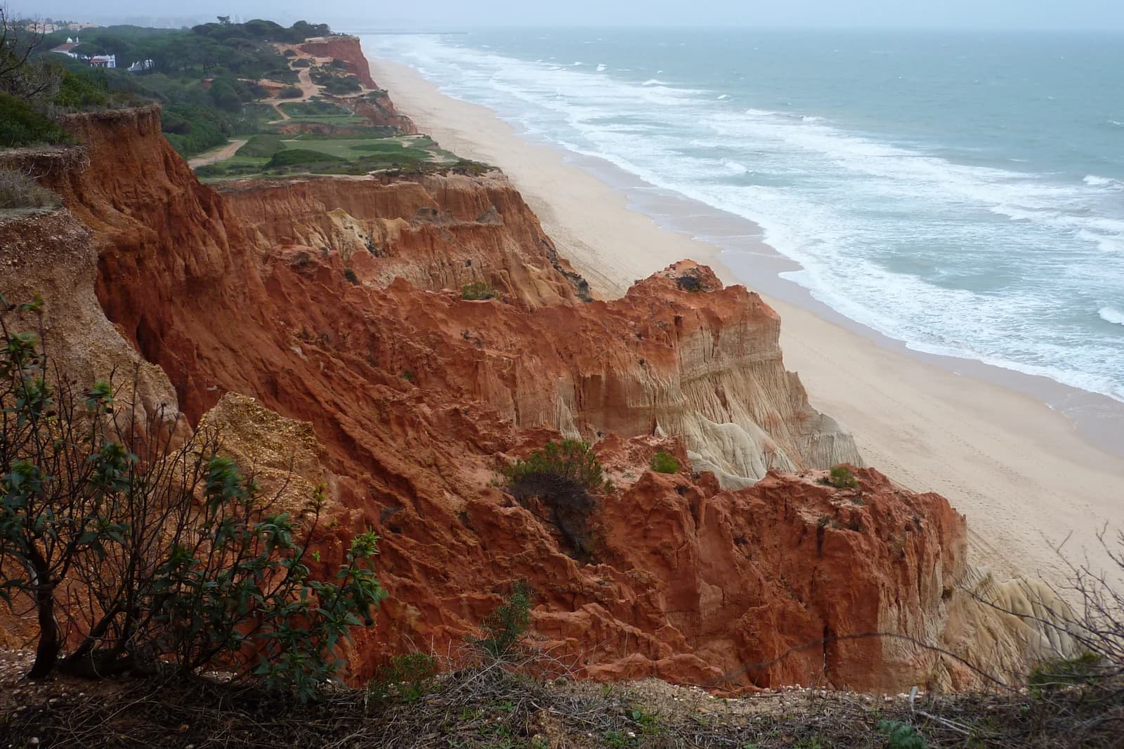 Red sandstone cliffs above the long sand of Praia da Falesia near Albufeira