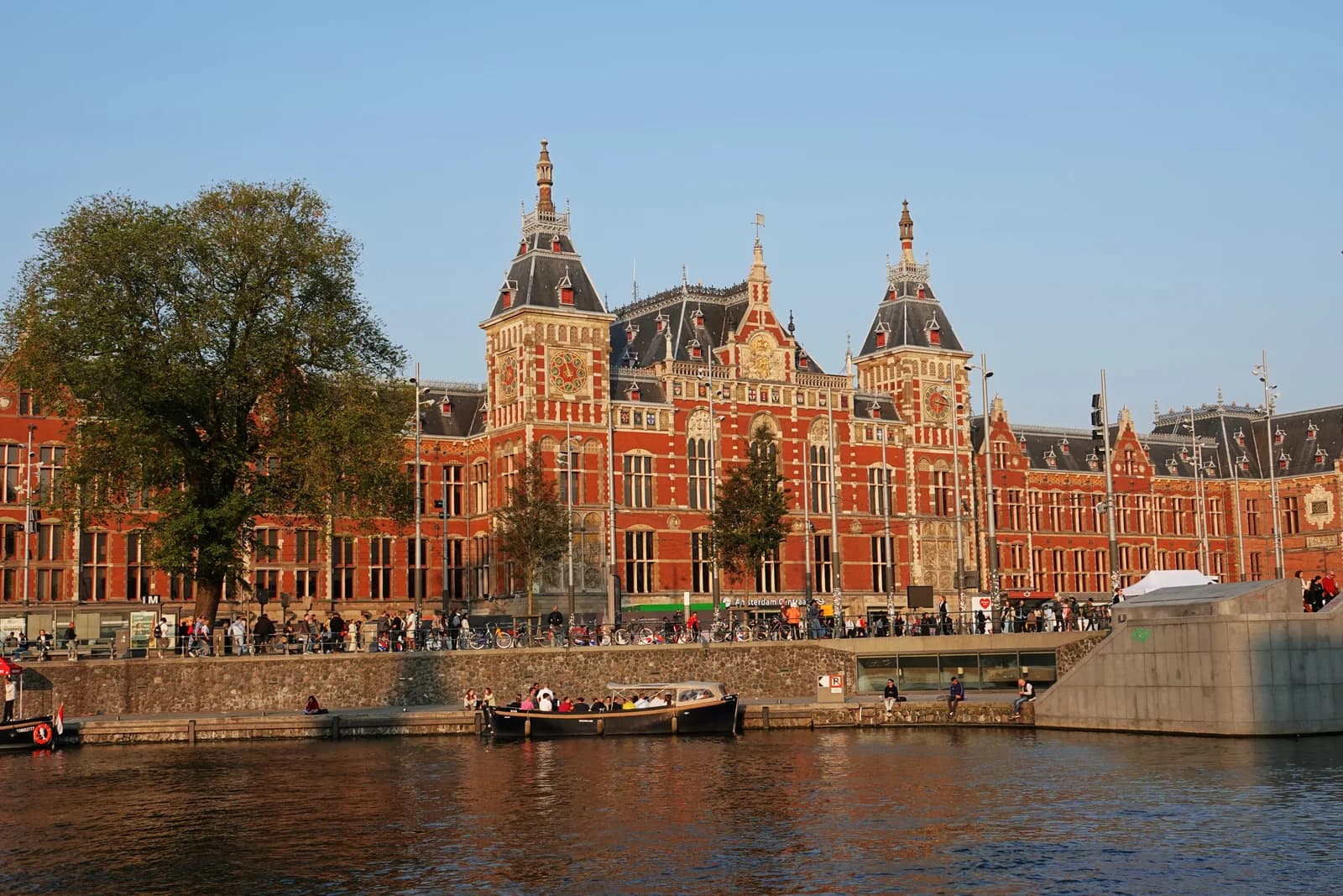 The red-brick front of Amsterdam Centraal Station seen across the water