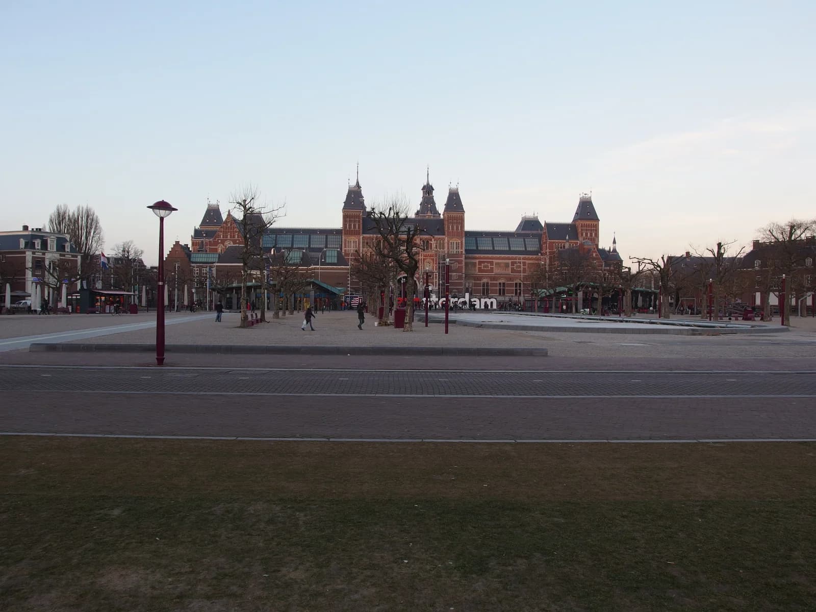 The Rijksmuseum seen across the open lawn and paving of Museumplein