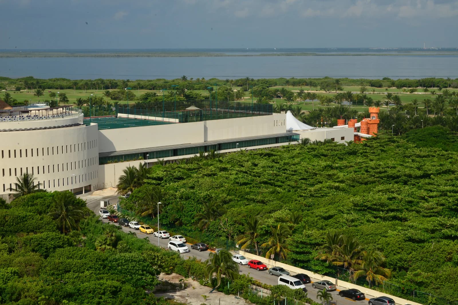 A golf course and the Nichupte Lagoon behind hotel buildings in the southern Hotel Zone