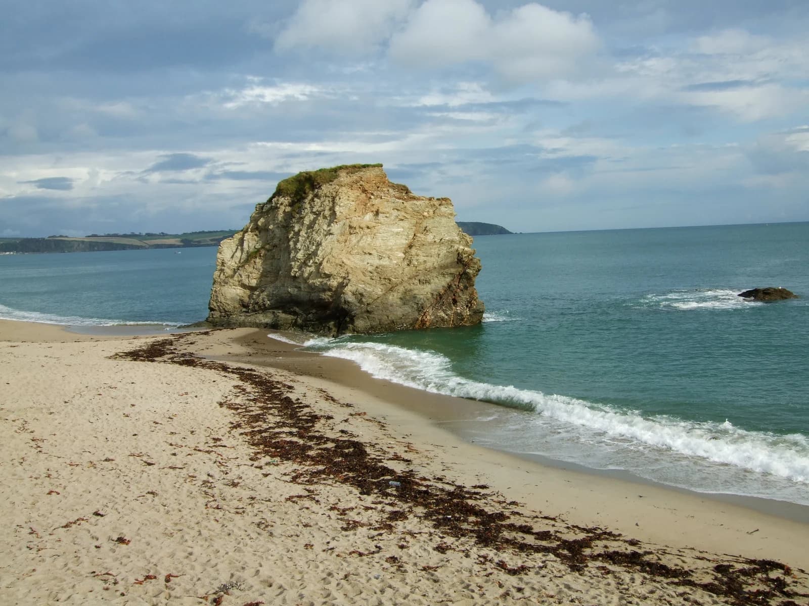 A rock stack standing off the sand at Carlyon Bay on Cornwall's south coast