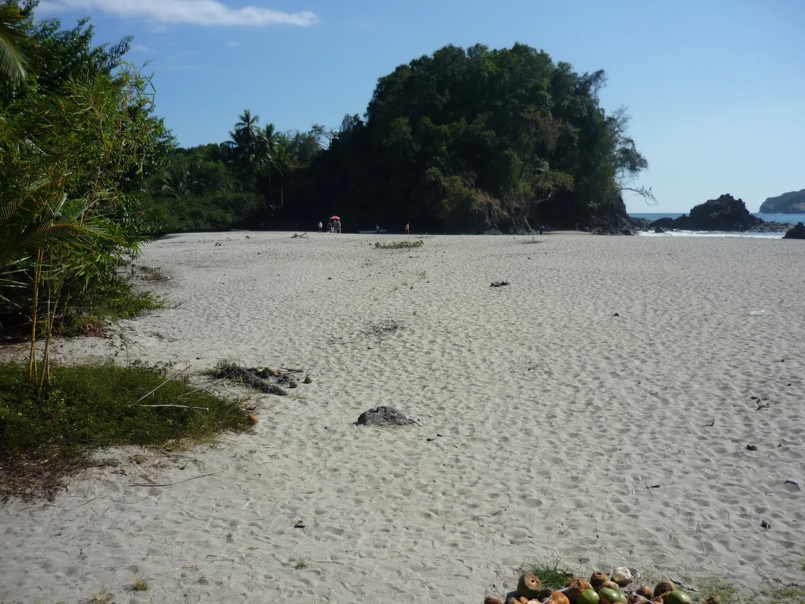 Pale sand of Playa Espadilla Norte at Manuel Antonio with a forested headland