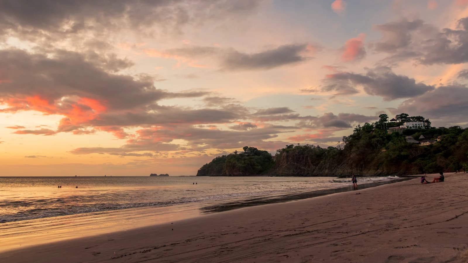 Playa Flamingo in Guanacaste at sunset with the wooded headland at the end of the beach