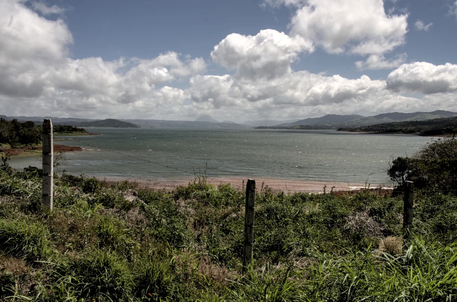 Lake Arenal under broken cloud with Arenal Volcano on the far shore