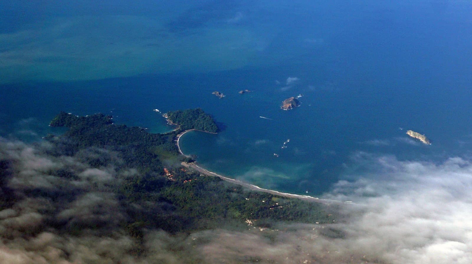 Aerial view of the forested Manuel Antonio coast, its curved beaches and offshore islets