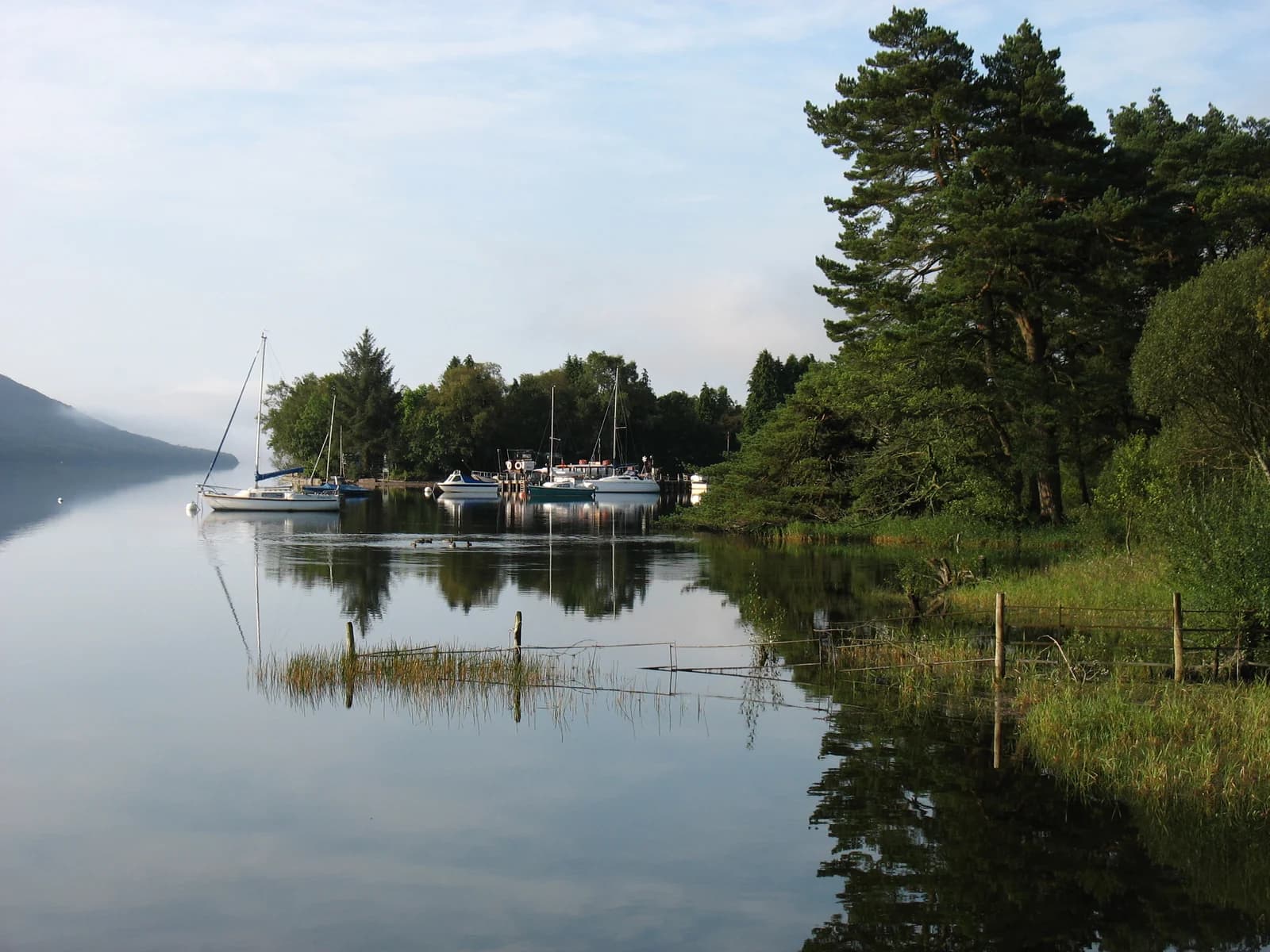 Yachts moored in still water at Waterhead, the northern end of Coniston Water
