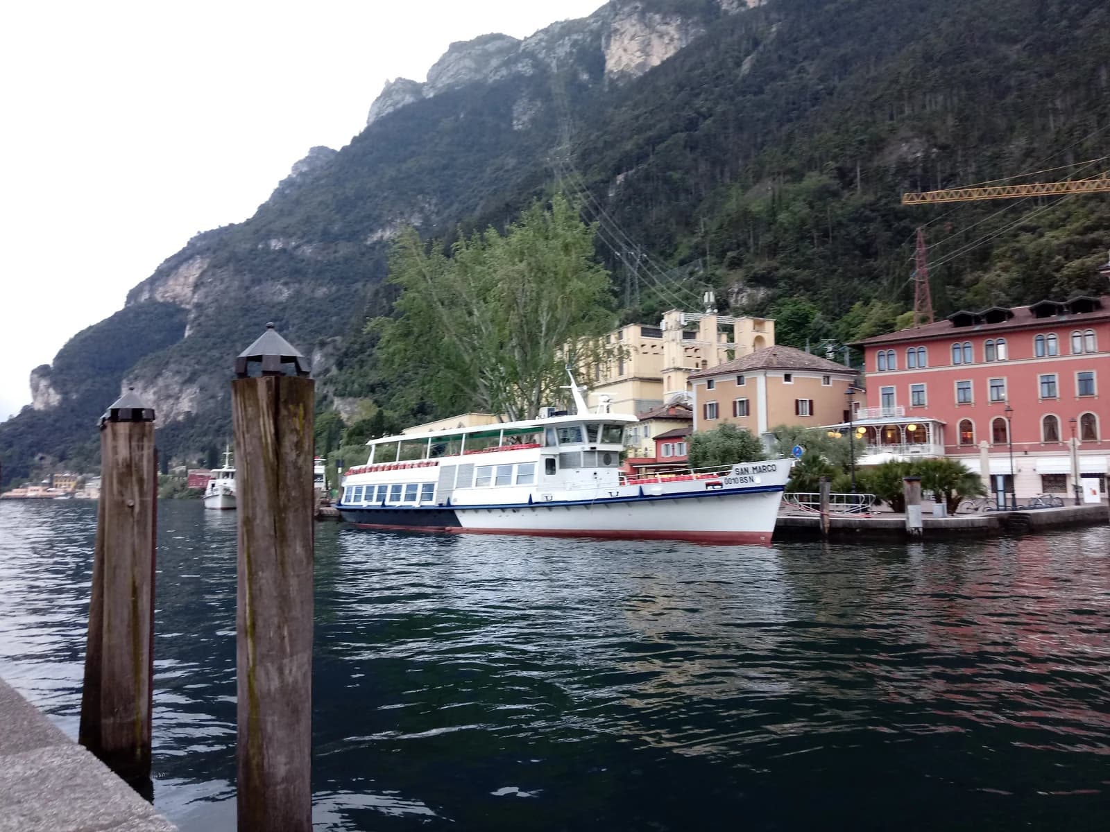 Lake ferries moored in the harbour at Riva del Garda under the cliffs
