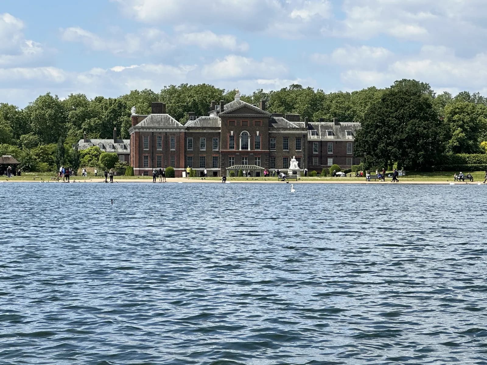 The Round Pond in Kensington Gardens with Kensington Palace behind it