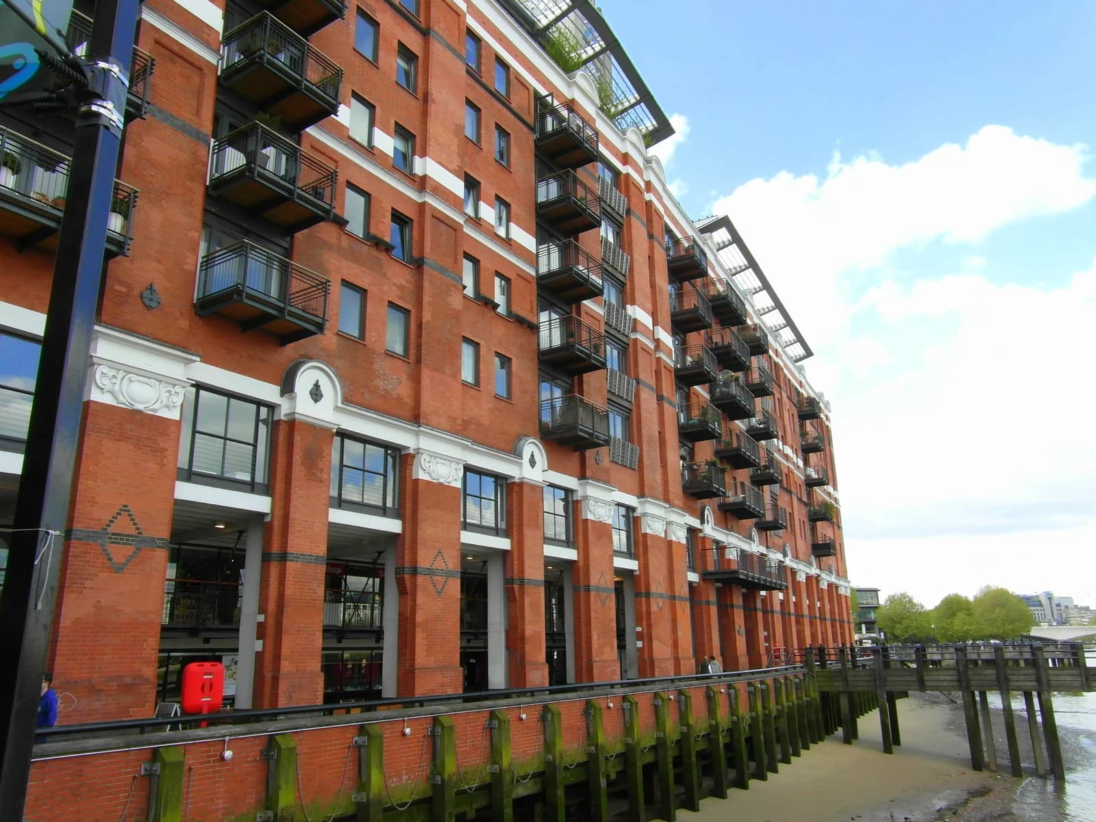The brick riverside block of Oxo Tower Wharf on the South Bank at low tide