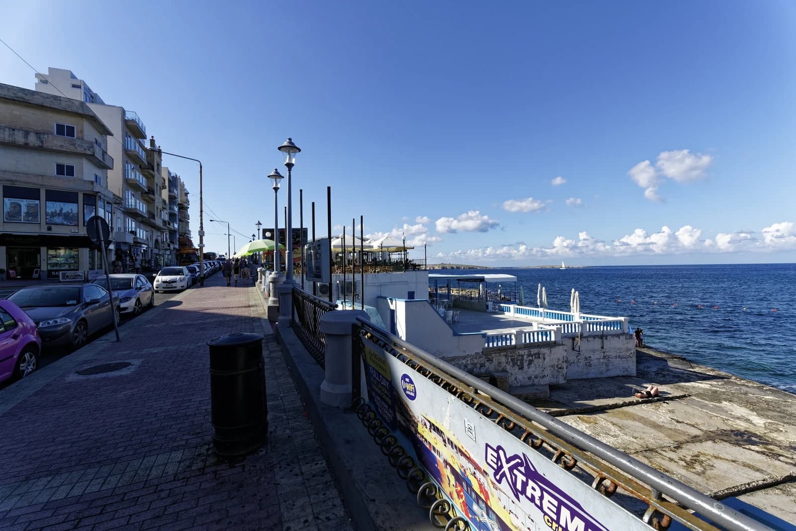 A lido built on the rocks beside the seafront promenade at Buġibba