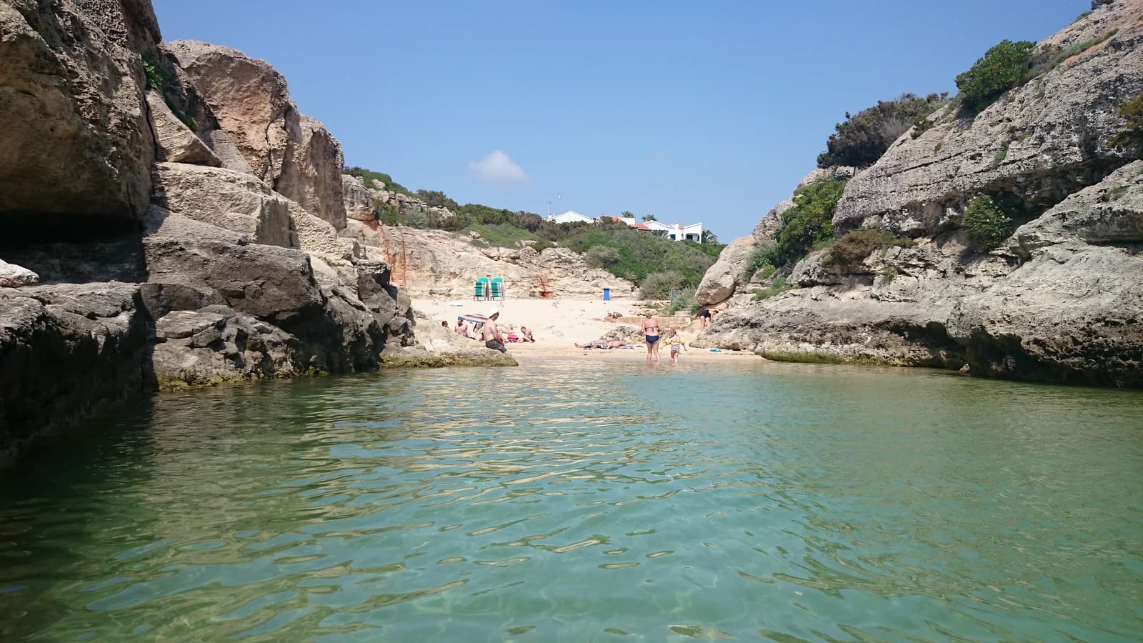 A narrow rocky inlet with a small beach at Los Delfines, next to Cala'n Forcat
