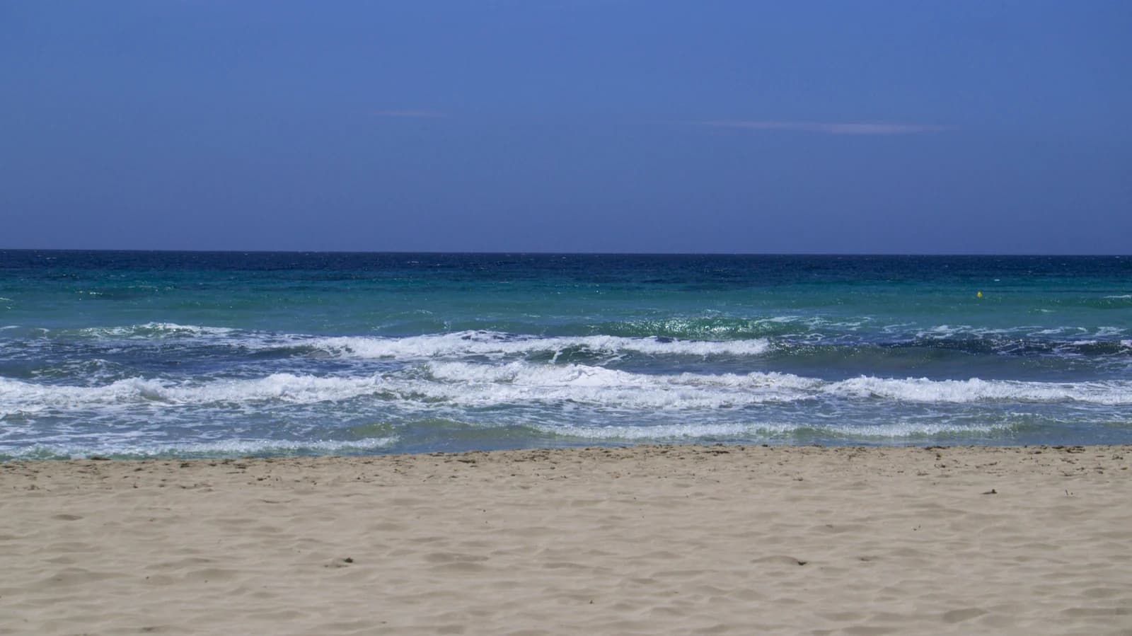 Waves breaking on the sand of Son Bou beach on Menorca's south coast