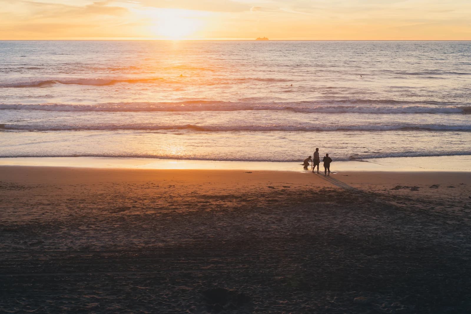 The sun setting over the sand and surf at Ocean Beach in San Francisco