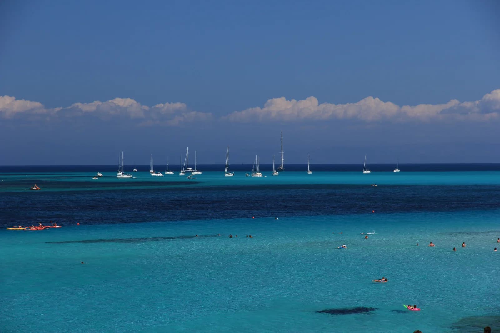Turquoise water and moored boats off La Pelosa beach at Stintino