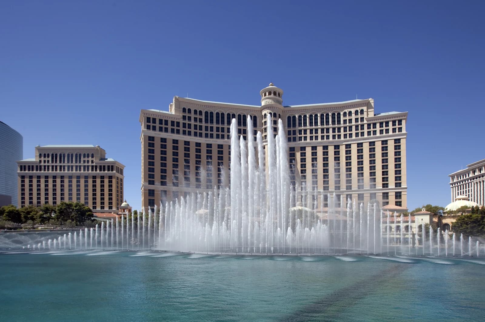 The fountains playing in front of the Bellagio hotel towers on the Las Vegas Strip under a clear blue sky
