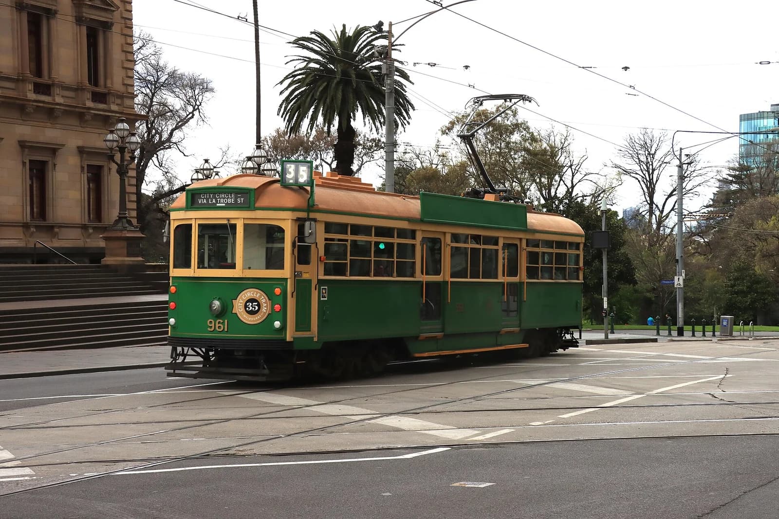 A maroon and gold City Circle tram crossing Collins Street on Spring Street in central Melbourne