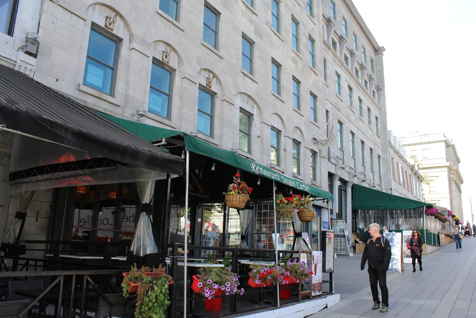 Terrace awnings and stone facades on Place Jacques-Cartier in Old Montreal, where most of the city's family suites sit