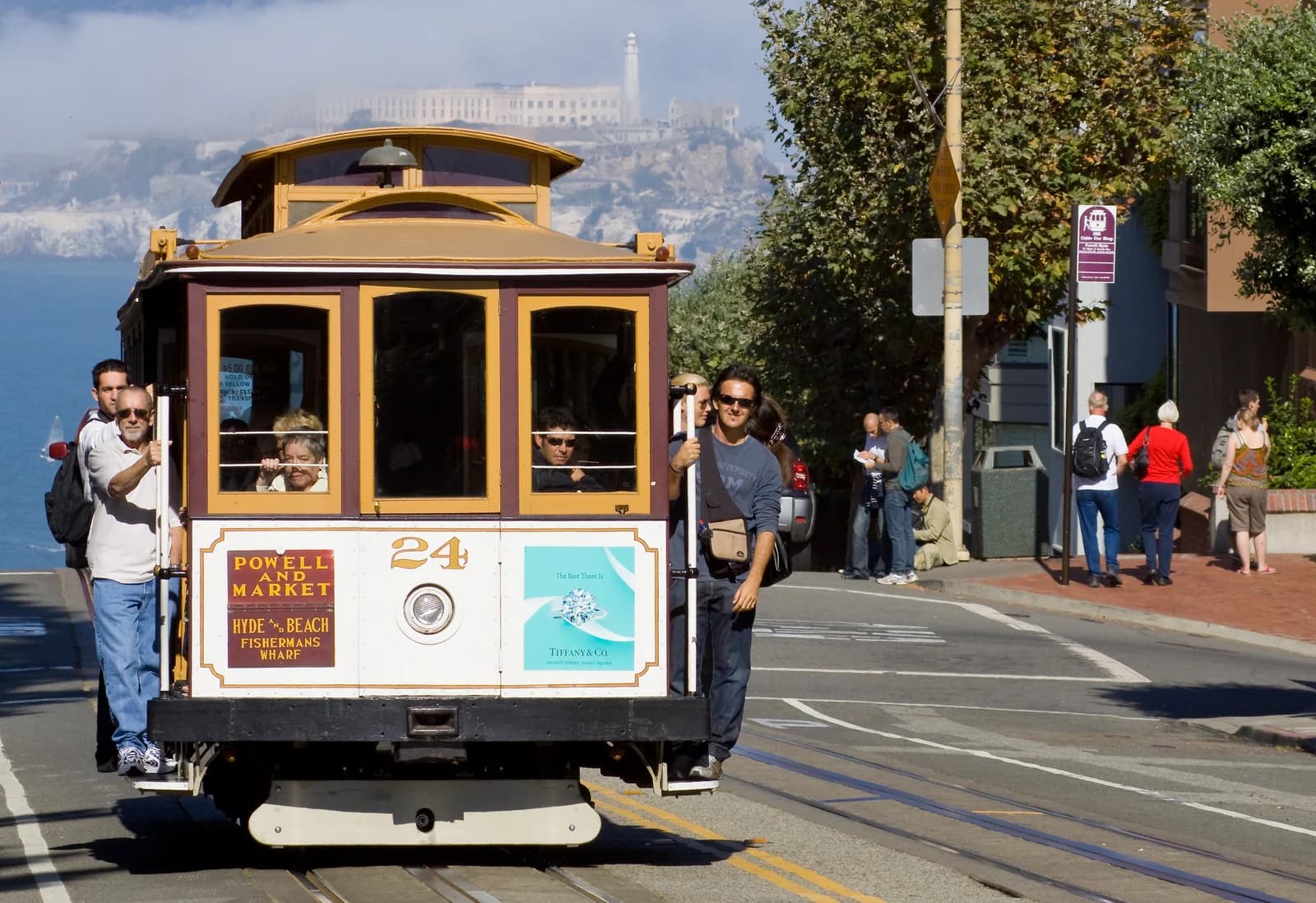 A San Francisco cable car with passengers riding on the running boards