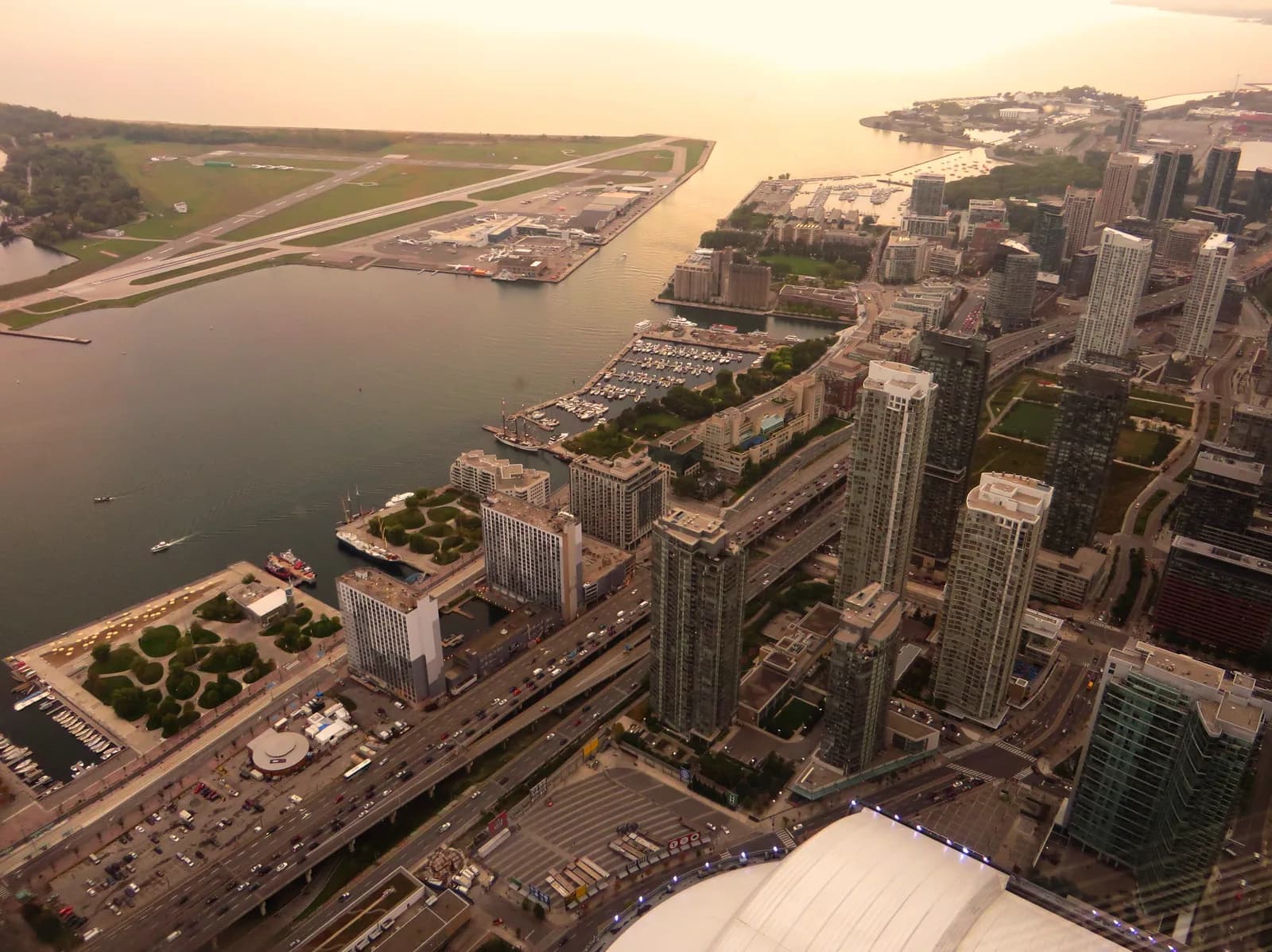 The Toronto harbourfront and South Core seen from above at sunset, the downtown blocks where the family suites sit