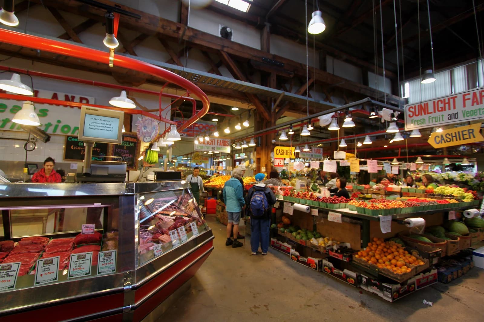 Produce and butcher stalls inside Granville Island Public Market in Vancouver