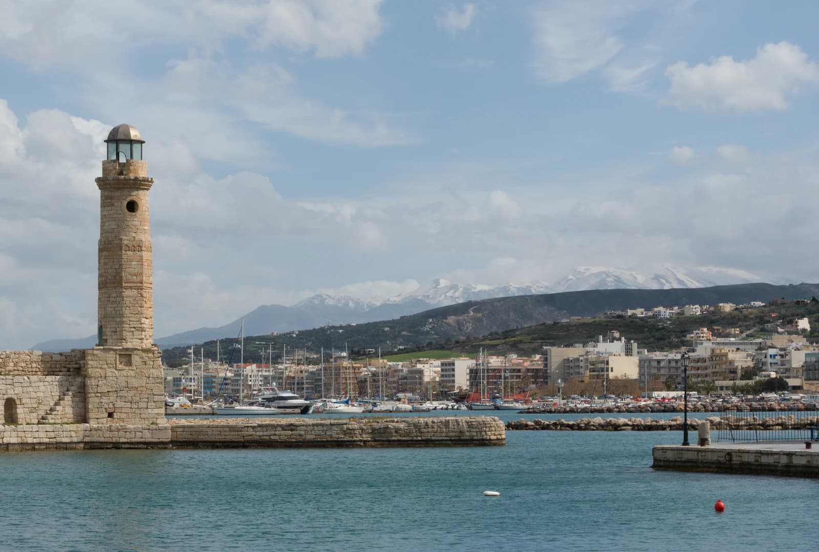 The Venetian lighthouse at Rethymno on Crete with the snow-topped mountains behind the town