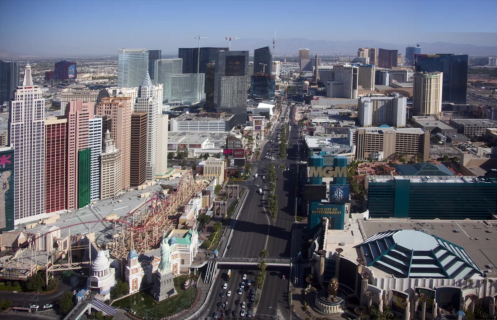 The Las Vegas Strip from above in daylight, with the New York-New York rollercoaster, the Excalibur towers and the MGM Grand along the boulevard