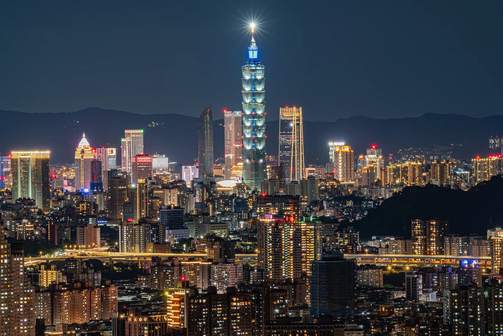 The Taipei skyline at night with Taipei 101 lit above the Xinyi district