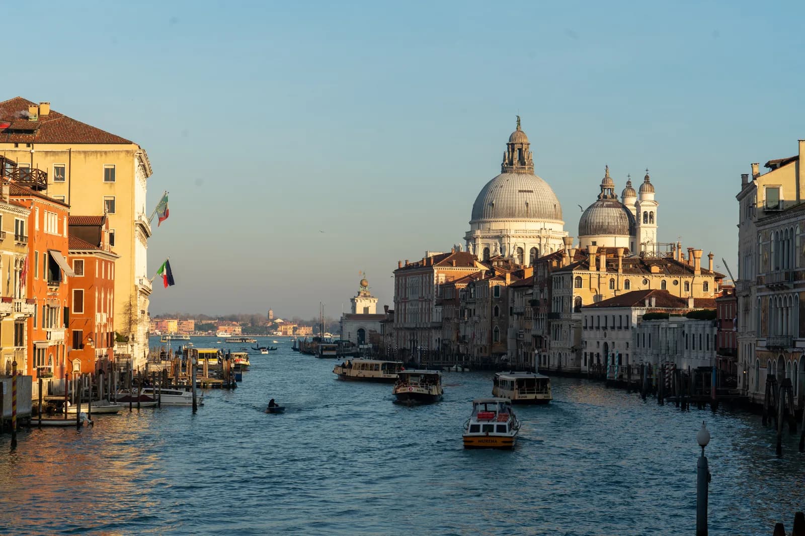 Grand Canal in Venice at golden hour with warm light on the domes of Santa Maria della Salute