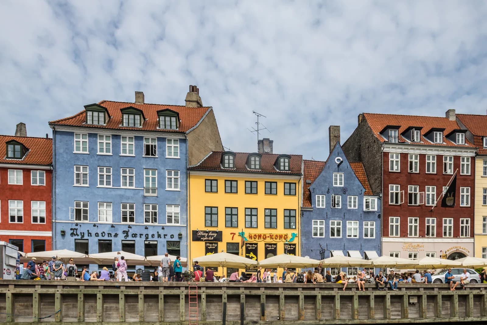 Colorful gabled townhouses and moored boats along the Nyhavn canal in Copenhagen on a bright summer day