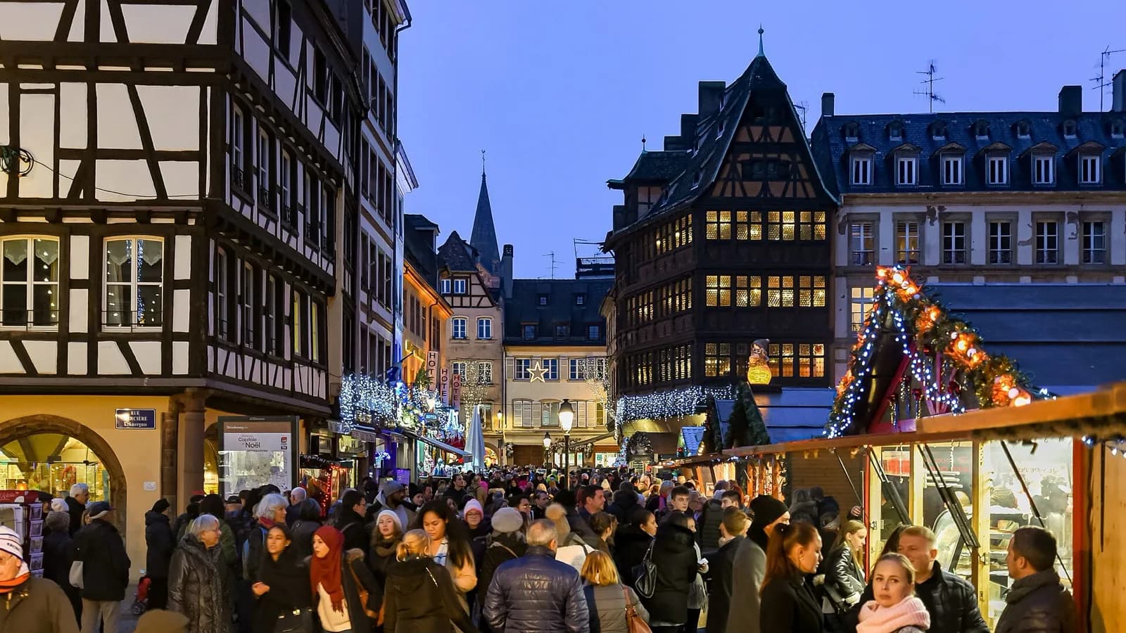 Illuminated wooden stalls and half-timbered houses at the Strasbourg Christmas market at night