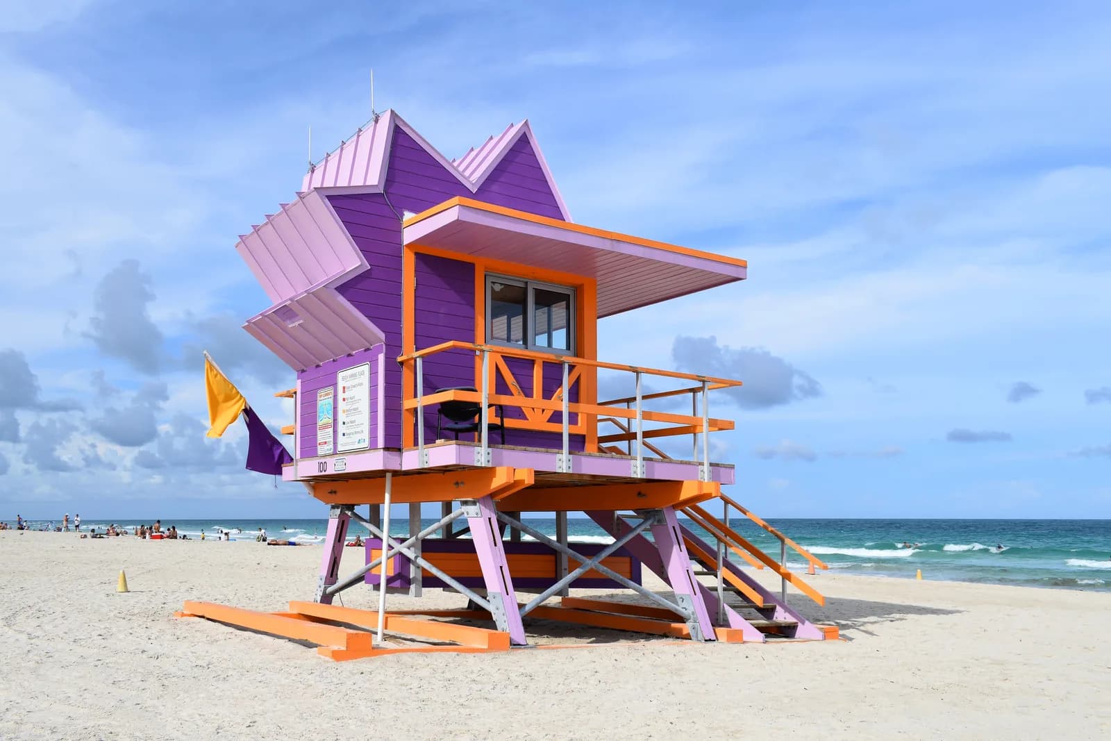 Colorful purple and orange art-deco lifeguard tower on the white sand of South Beach, Miami