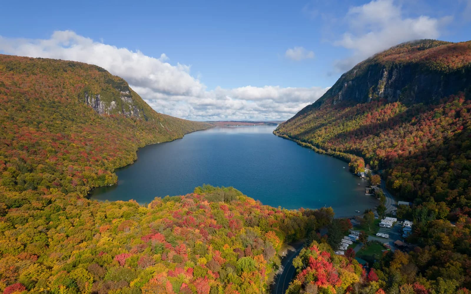 Aerial view of Lake Willoughby in Vermont surrounded by red, orange and gold fall foliage