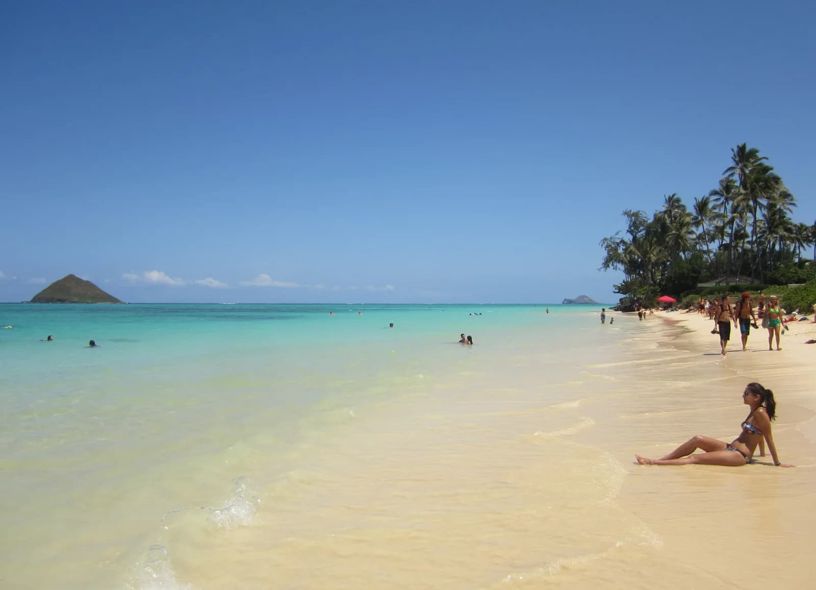 Golden sand and turquoise shallows of Lanikai Beach on Oahu with the Mokulua islands offshore