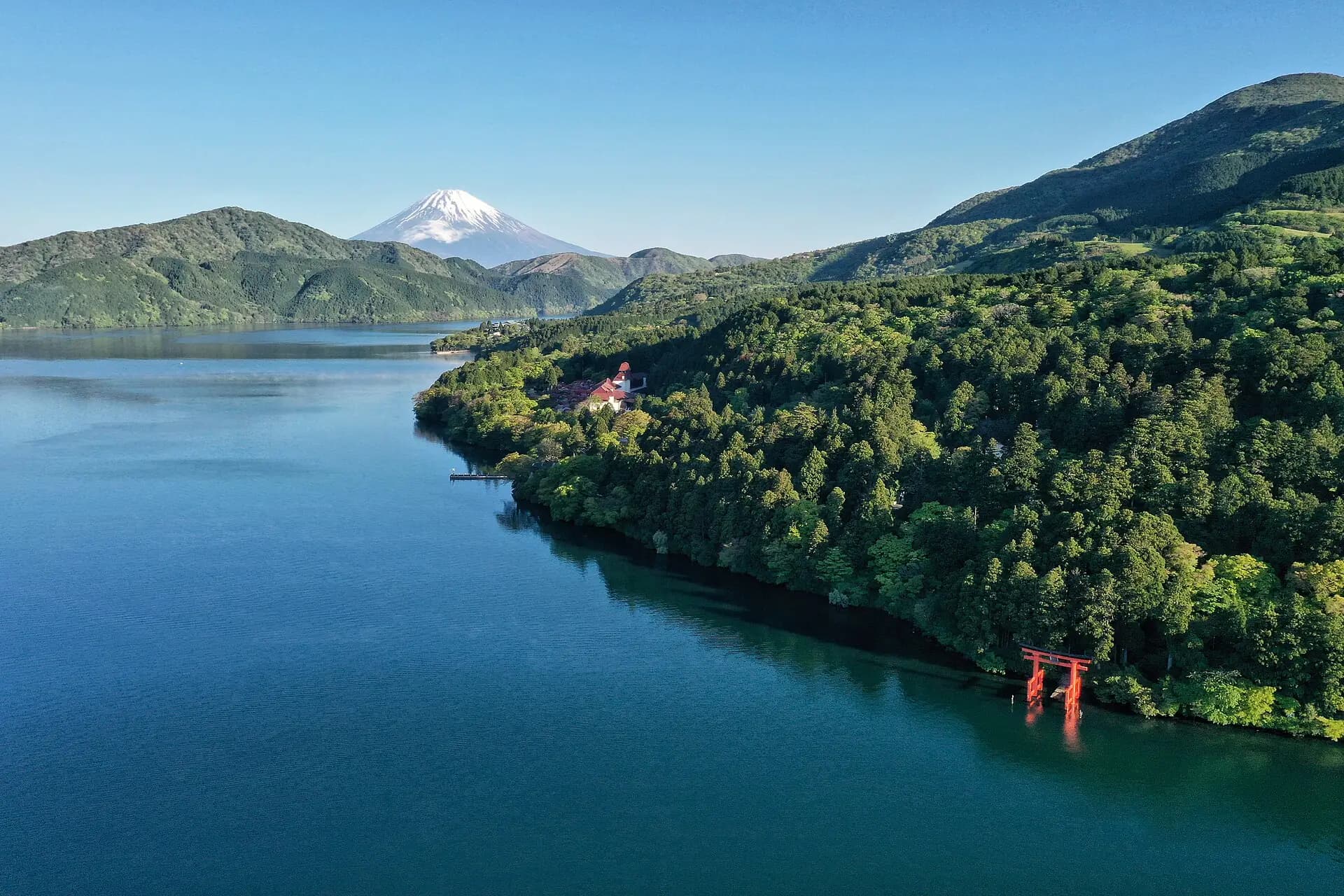The red torii of Hakone Shrine standing in Lake Ashi with Mount Fuji behind