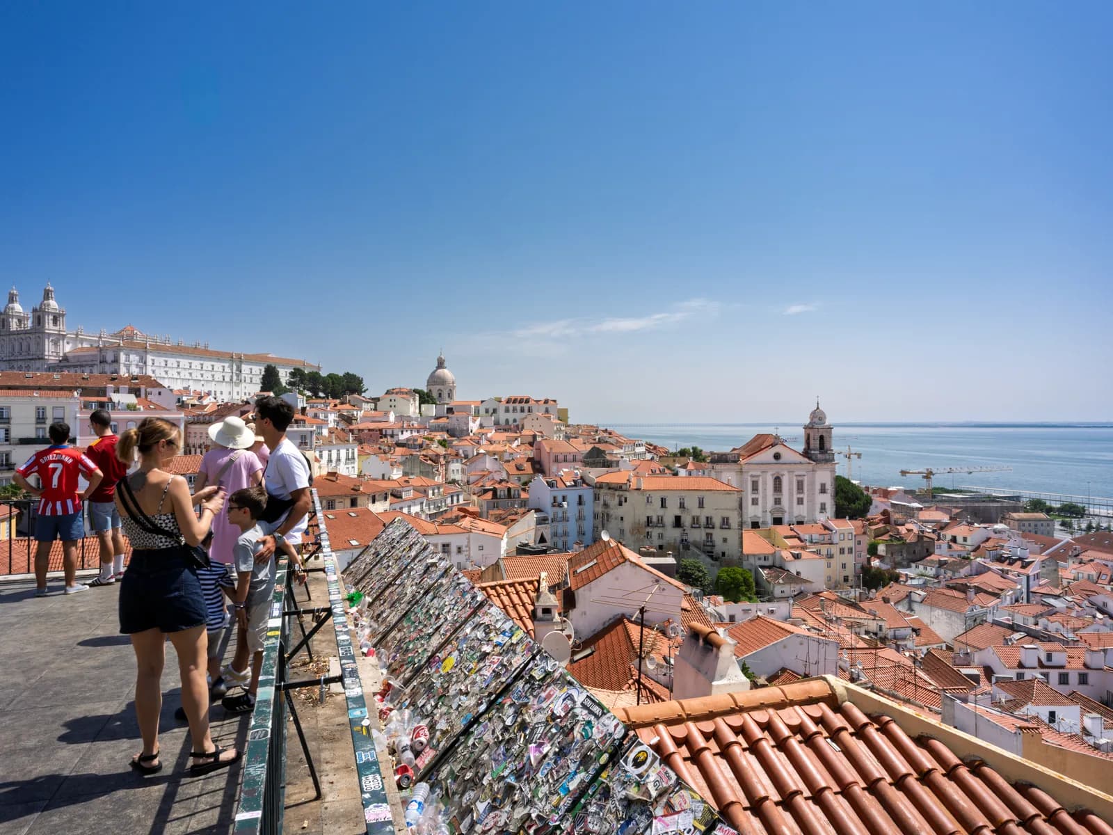 Alfama's terracotta rooftops seen from the Miradouro de Santa Luzia viewpoint, with the Tagus beyond