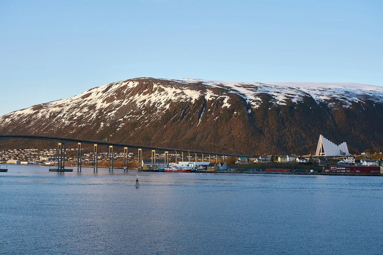 The Tromso bridge crossing to Tromsdalen with the Arctic Cathedral and snow dusted mountains behind it