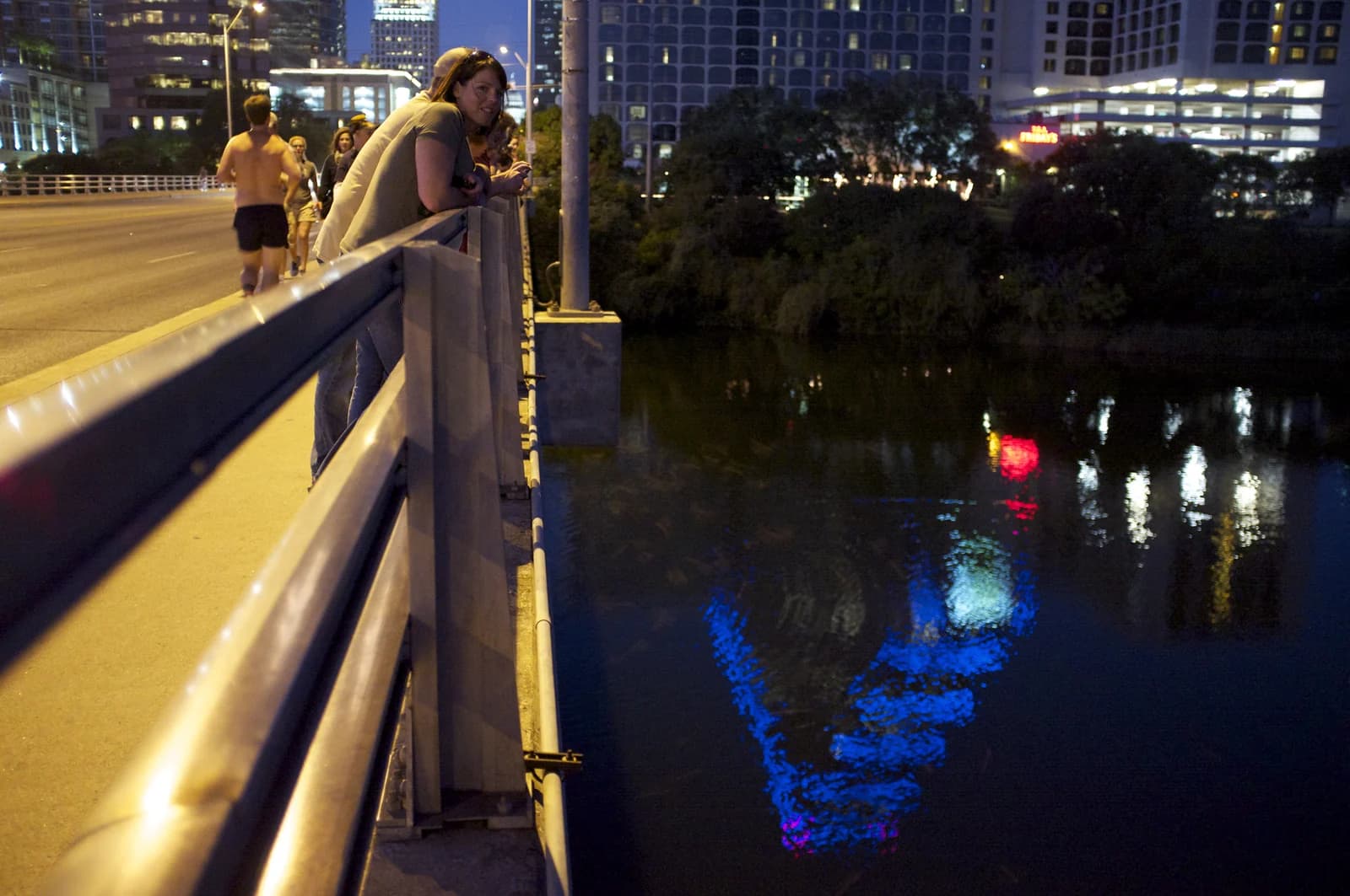 People waiting at dusk on the Congress Avenue Bridge above Lady Bird Lake to watch the bats