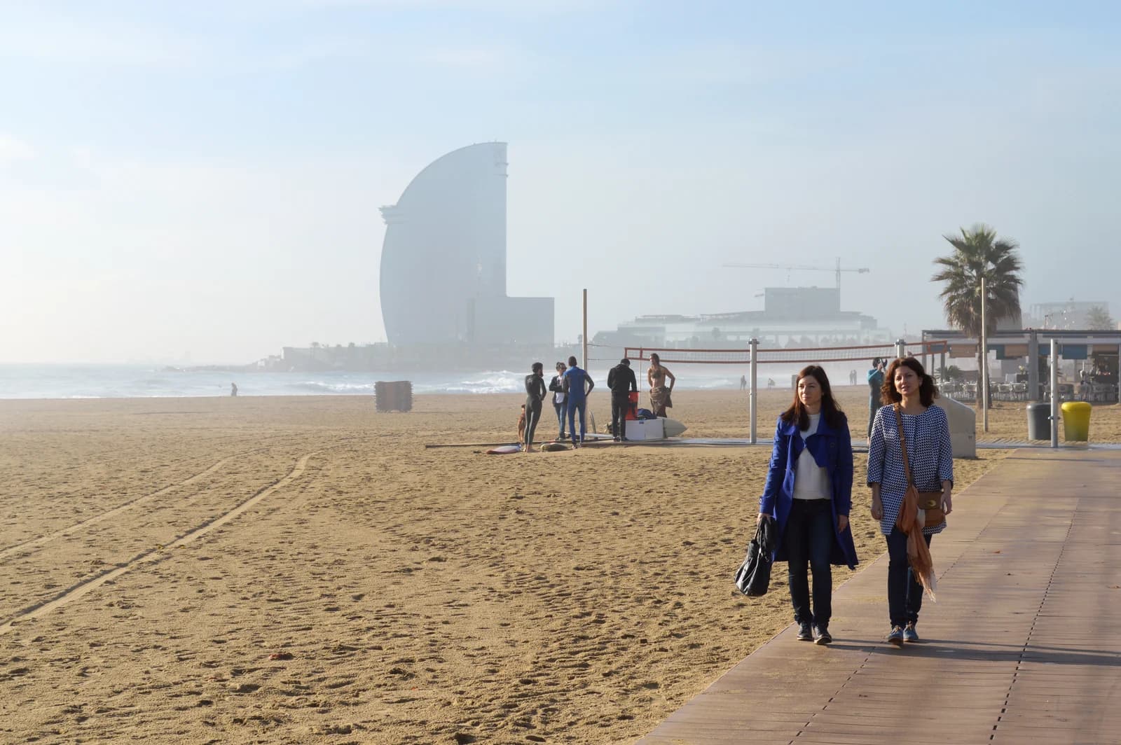 Early morning walkers on the sand at Platja de la Barceloneta