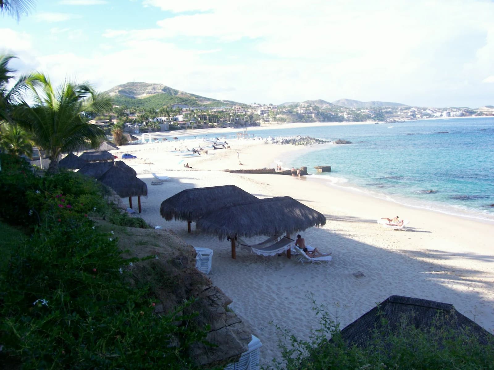 Palapas and calm shallow water at Playa Palmilla on the Los Cabos tourist corridor