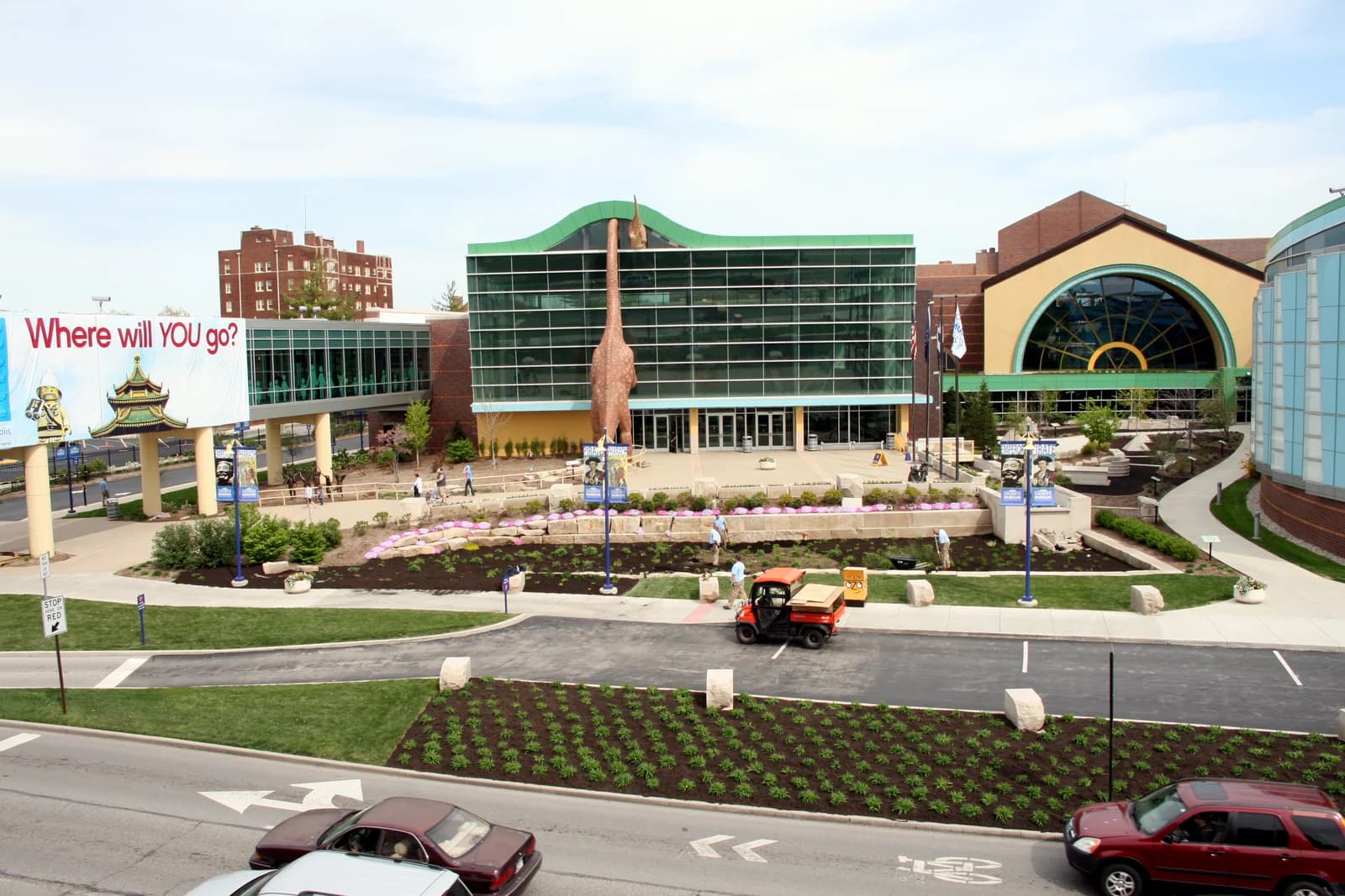 The curved glass frontage of the Children's Museum of Indianapolis with its outdoor dinosaur sculpture