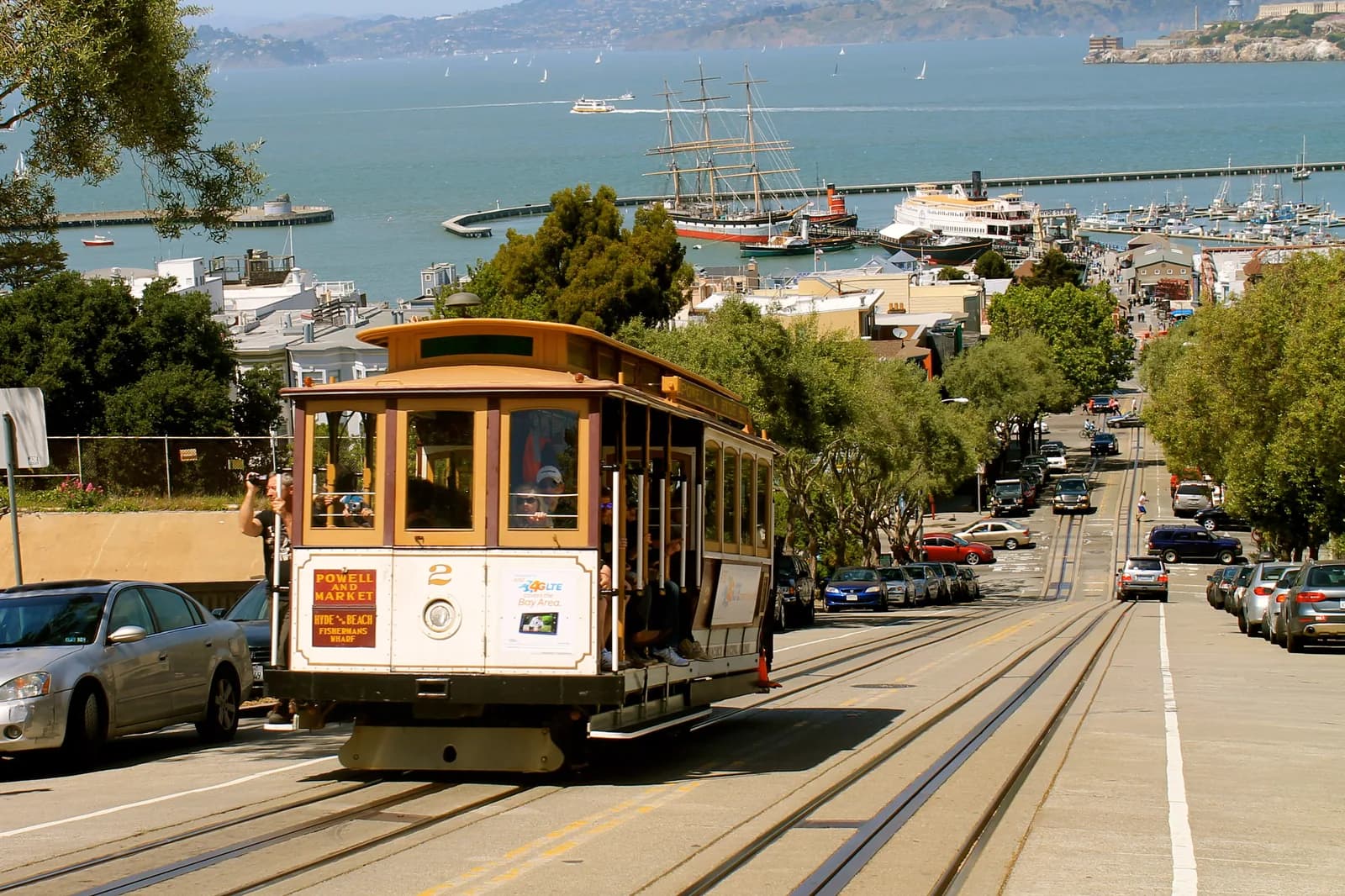 A Powell-Hyde cable car cresting the hill above the bay in San Francisco, free for children aged four and under