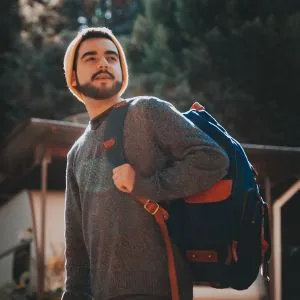 Harry, who writes the Journey Finder budget travel guides, carrying a backpack in the late afternoon sun